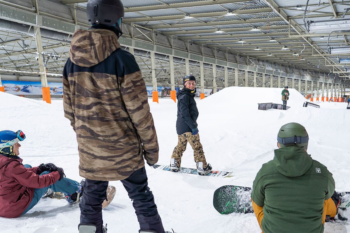 Man snowboardend stilstaand op een piste