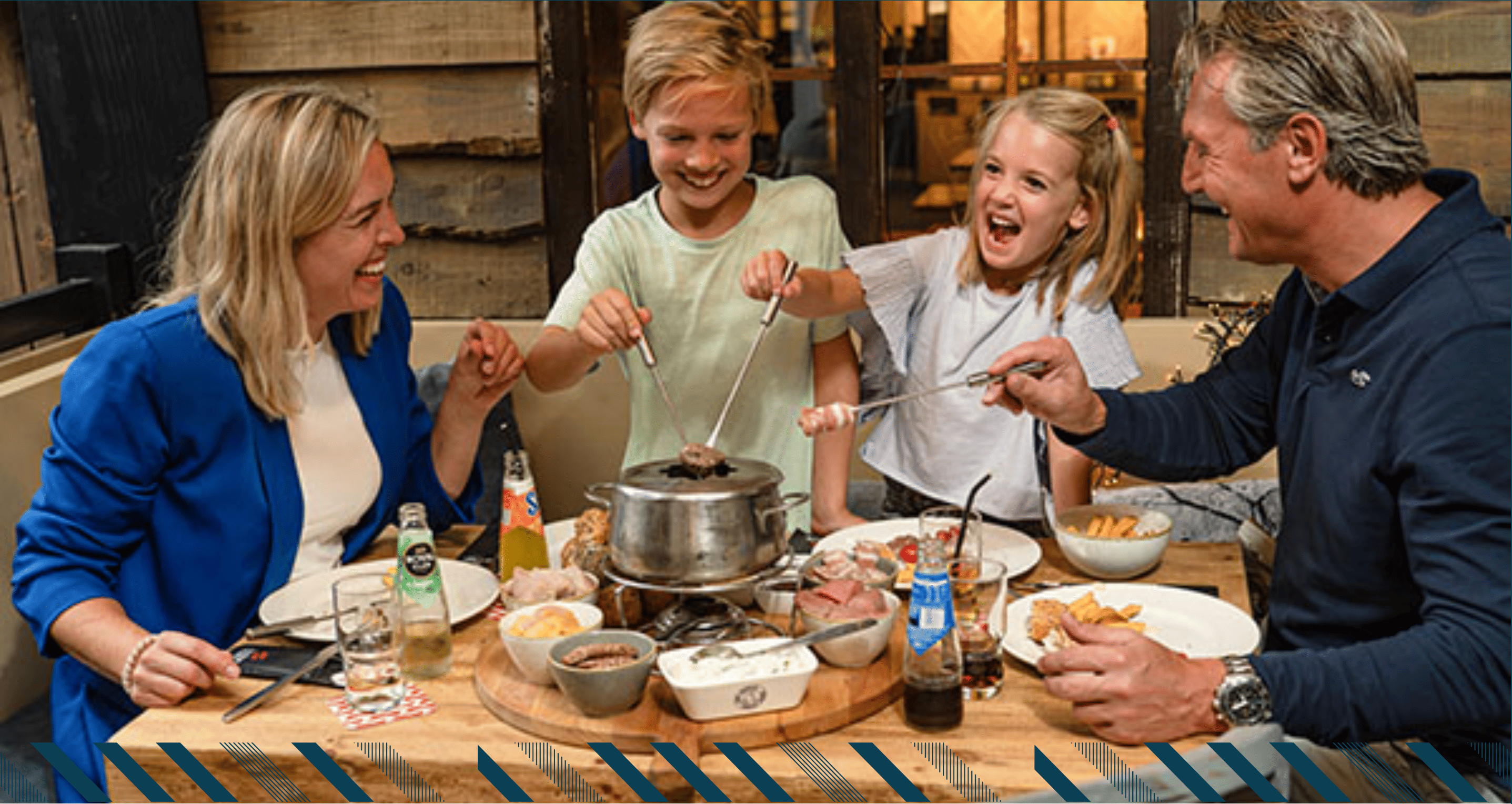 Twee kinderen en ouders random een tafel met een maaltijd van fondue