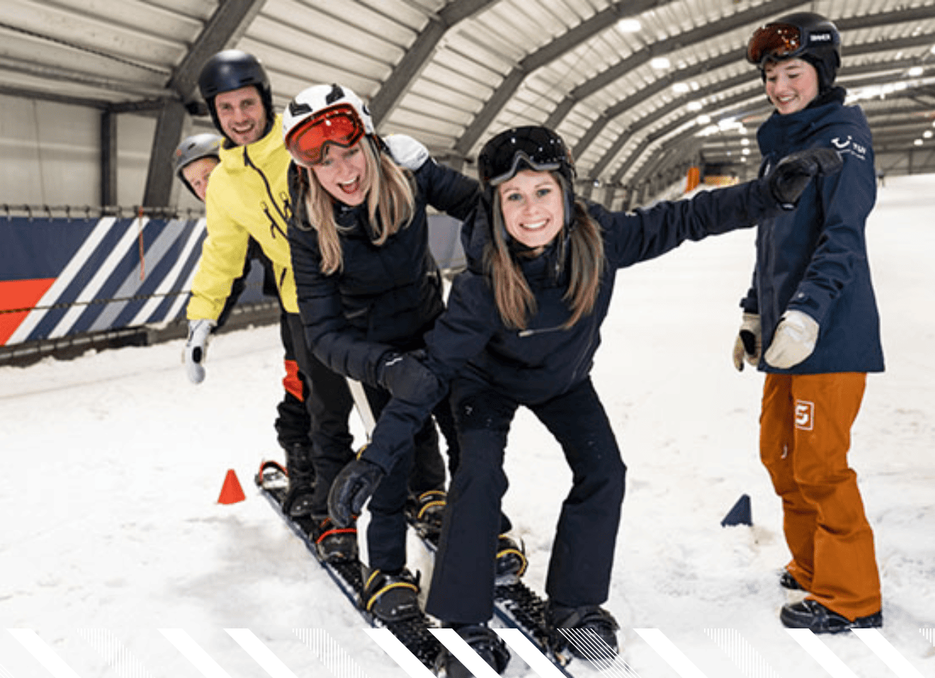 Een groep mensen allemaal blij samen aan het skien in een rij op een piste